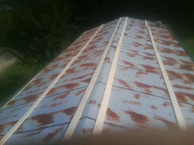 Rusted metal roof panels with new wood purlins before replacement — Storm Damage Roof Repair in New Bedford by Roofing Brothers